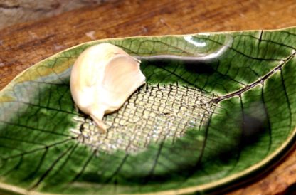 Detailed photo of Ceramic garlic grater plate with garlic on top
