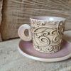 Photo of ceramic coffee cup with handle and saucer in pink colour